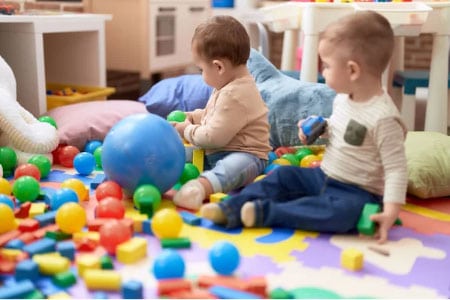 Children playing with colorful balls and toys in a daycare setting.