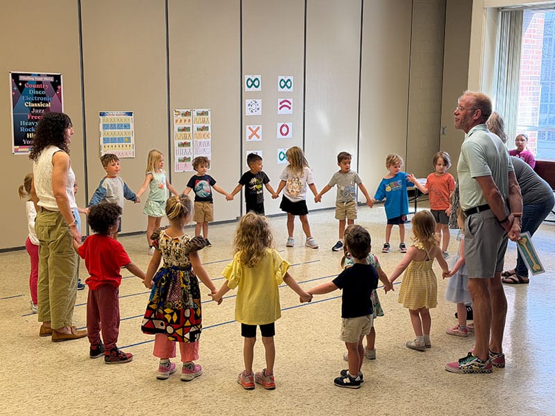 Children and adults holding hands in a circle at First United Methodist Church of Sarasota.